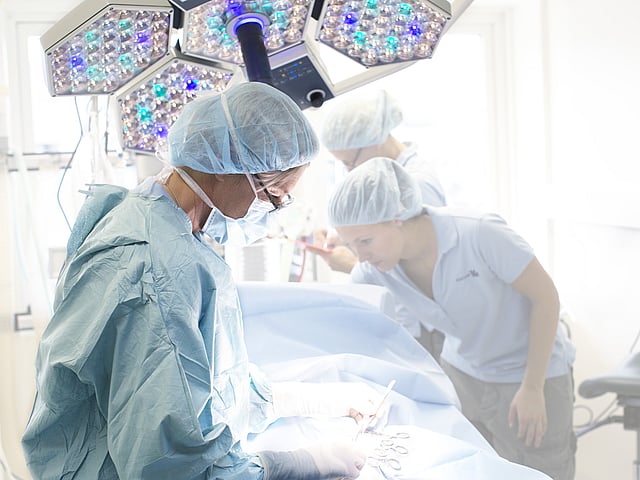 En gruppe mennesker i kirurgisk utstyr.