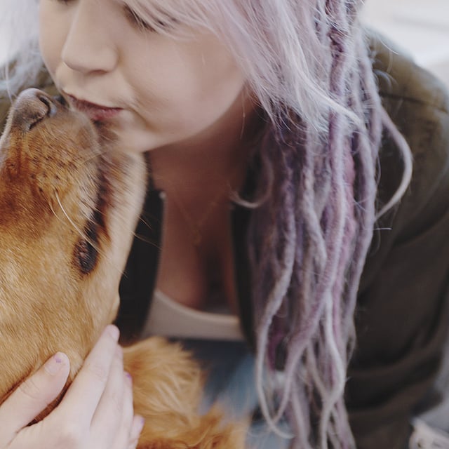 En person som kysser en hund.