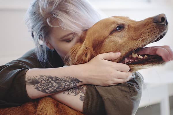 En person som klemmer en hund.