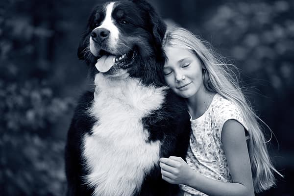 Et barn som klemmer en hund.