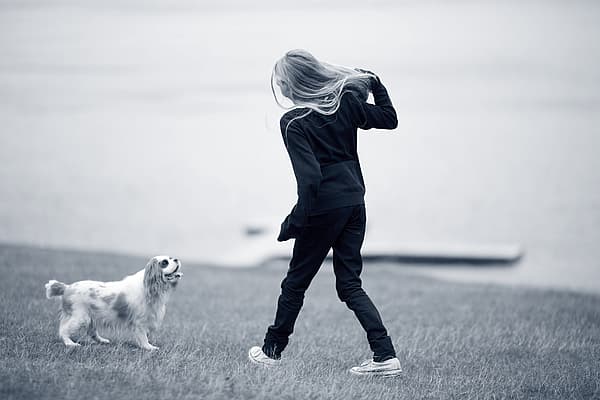 Et barn som går tur med en hund.